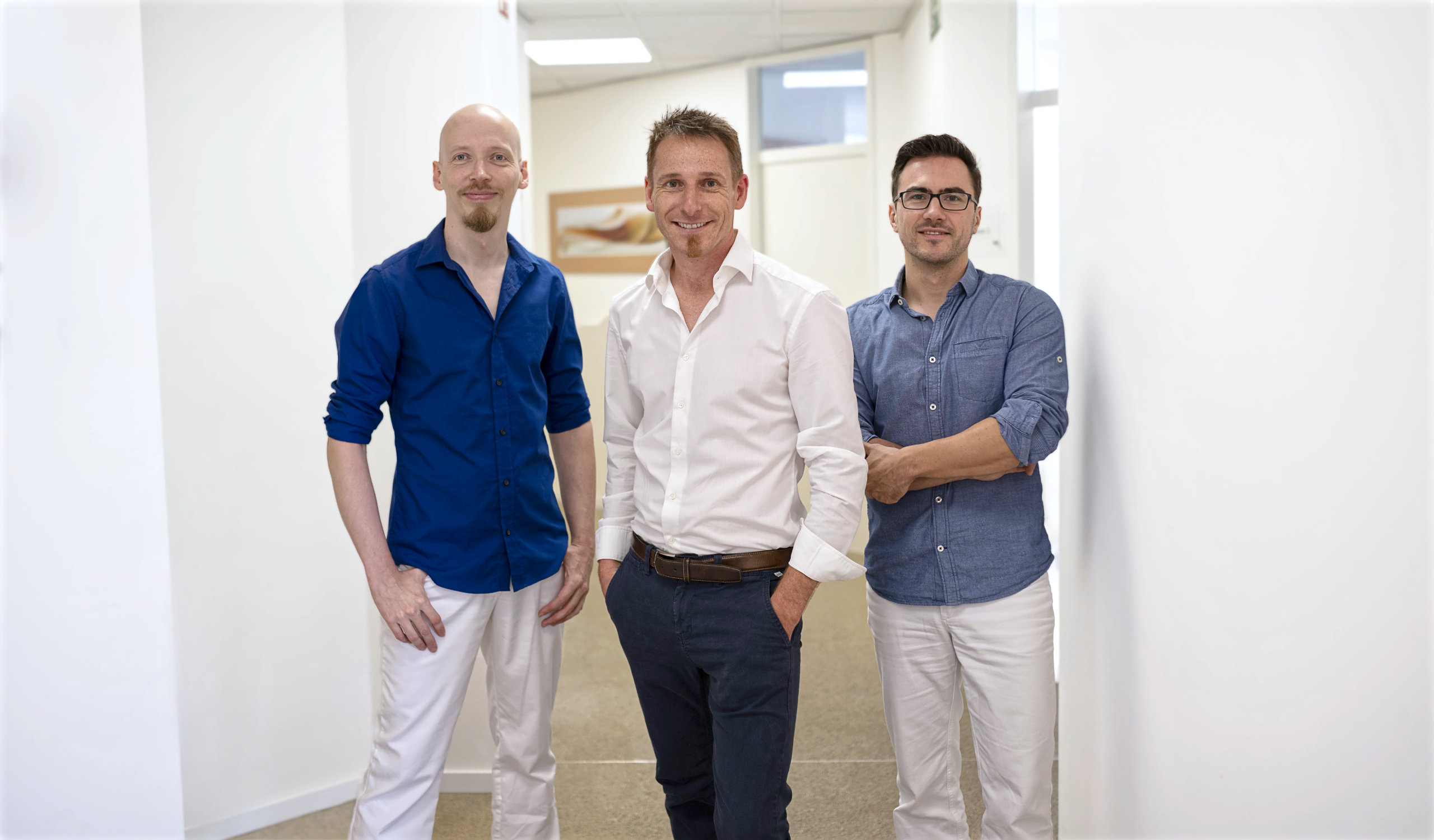 3 Zahnärzte stehen im Praxisflur nebeneinander, von links nach rechts Philipp Schmidt, Dr. Florian Steib und Philippe Kocher